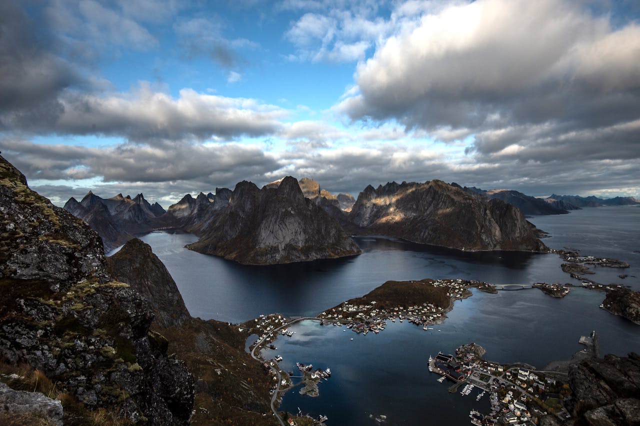 Services Breathtaking aerial view of Lofoten Islands' fjord, capturing rugged mountains and serene waters.