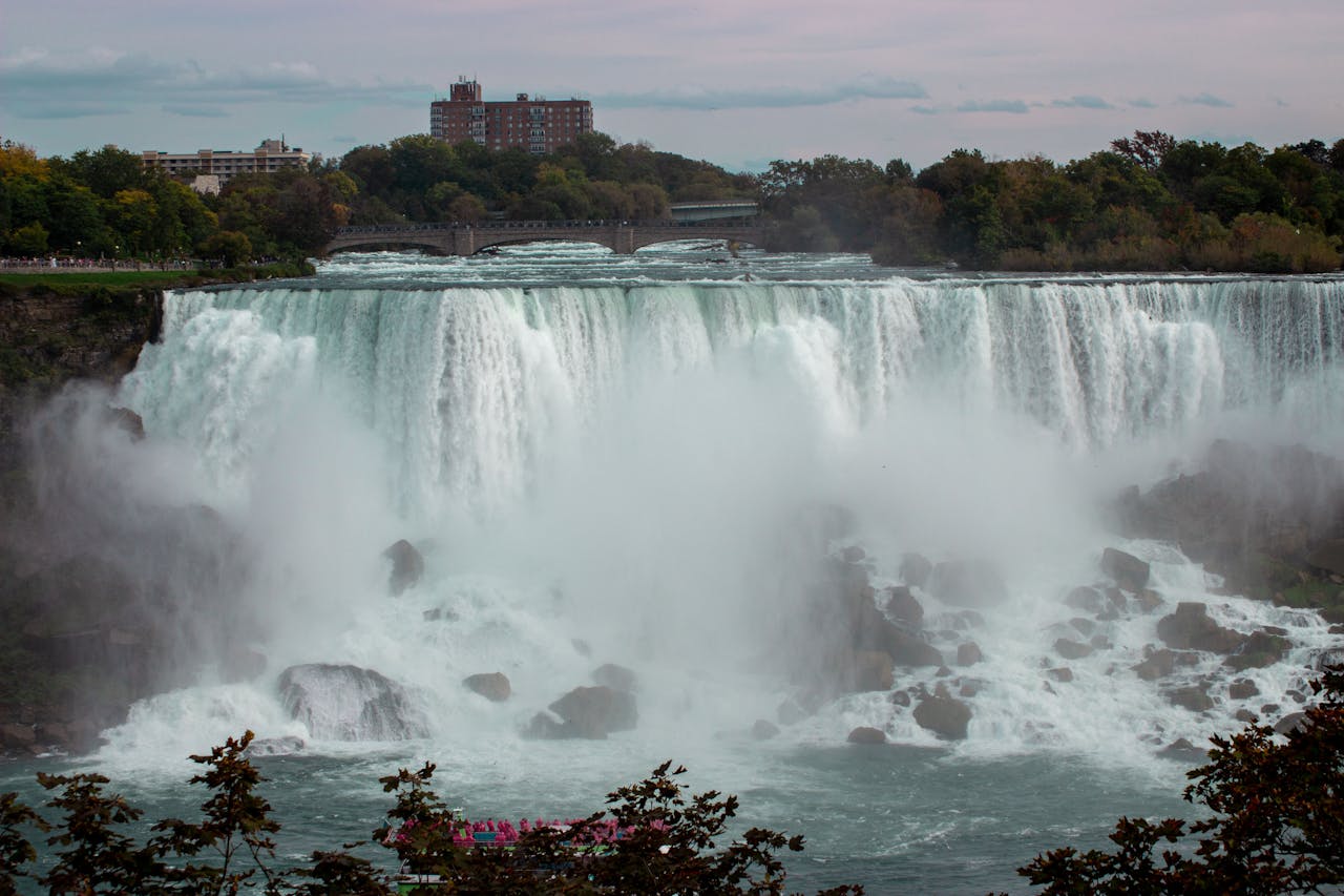 Services Majestic view of Niagara Falls cascading into the river below on a calm day.